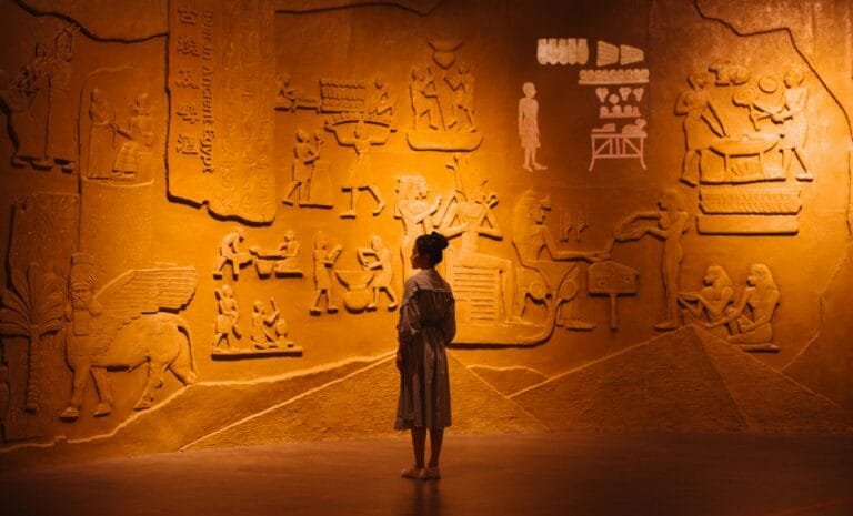 Egyptian wall with women in front of it