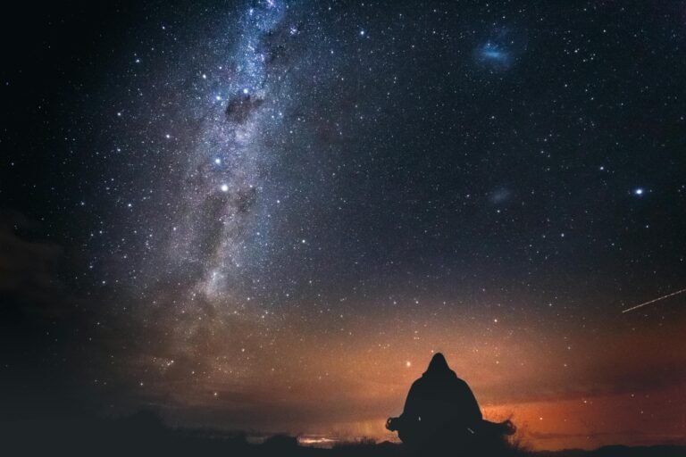 Persoon die in stilte naar de sterrenhemel kijkt onder de melkweg, symbool voor reflectie en een astrologisch gesprek dat nieuwe inzichten opent. foto: Marek Piwnicki